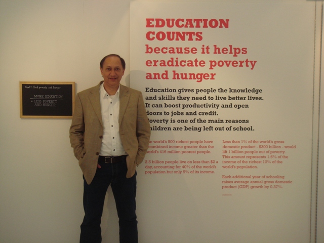 Chris standing next to the Education Counts exhibition inside the UN Building