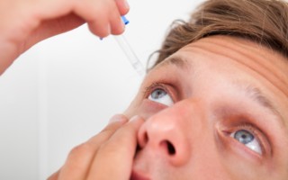 Close up of male inserting eye drops